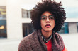 © Andrii - Close-up portrait of a young handsome curly guy. The headshoot of an Egyptian student. Serious facial expression