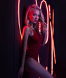 © Andrii - Fashion art photo of elegant model in seductive red swimsuit with light neon colored club spotlights