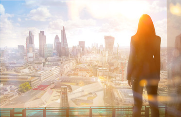 Poster - Young woman looking over the City of London at sun set. Future, new business opportunity and business success concept.