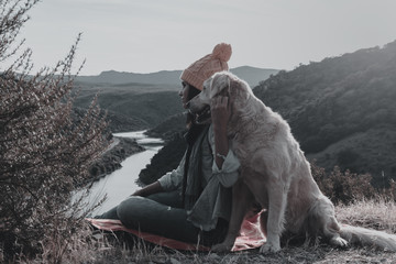 Young girl traveling by nature with backpack and dog