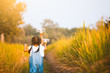 Two cute asian child girls running and playing with toy wooden airplane in the field at sunset time together with fun