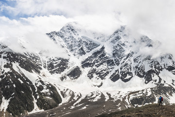 Panoramic view of high mountain peaks in snowy and foggy cold weather. Glacier Semerka, Elbrus region