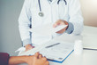 © joyfotoliakid - Doctor or physician writing diagnosis and giving a medical prescription to female Patient