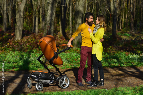 Fényképezés Married couple enjoy walking in spring park with baby pram