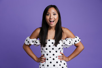 Wall Mural - Portrait of a cheerful asian woman in dress standing