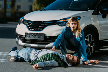 Wall Mural - young woman looking at camera while touching victim of motor vehicle collision