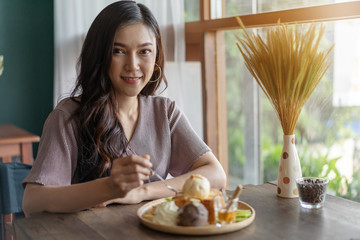 Wall Mural - woman eating honey toast, sweet dessert in cafe