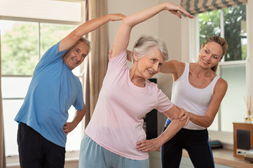 Wall Mural - Physiotherapist helping senior couple exercise