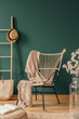 © Photographee.eu - Wicker armchair with beige blanket, real photo with copy space on empty green wall