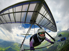 Aerial Shot Of Brave Extreme Hang Glider Pilot Soaring The Thermal Updrafts Above Mountains