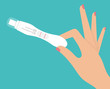 Woman's hand holding positive pregnancy test