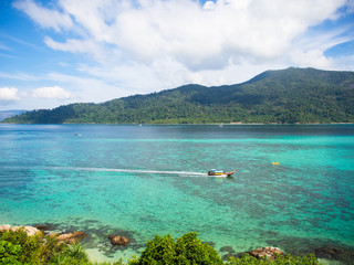 Poster - Aerial view of Koh Lipe island in Thailand,long tail boat in turquoise water sea,green moutain,cloud and blue sky in sunny summer day for travel destination or vacations holiday concept.