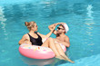 © New Africa - Happy young couple with inflatable ring in swimming pool