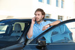© New Africa - Young man talking on phone near modern car, outdoors