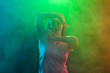 Close up of dancing young woman on colourful background