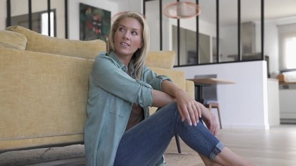 Wall Mural - Upper view of attractive blond woman sitting on wooden floor