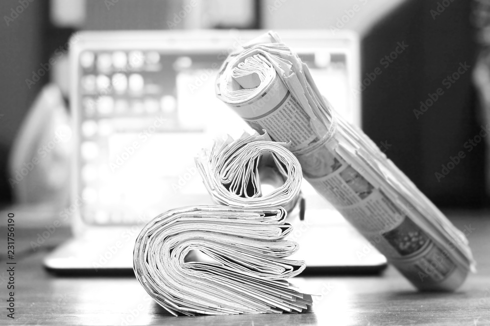 Tabloid Device Newspapers and computer. Folded and rolled papers and magazines on ...