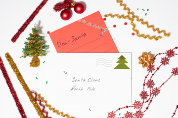 letter of red paper and a white envelope to Santa Claus on a white background, around the Christmas decorations