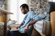 © Stocksy - Young man sitting on the floor using laptop