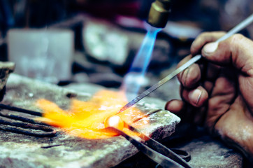 Master soldering jeweller ornament. Picture of hands and product close up.