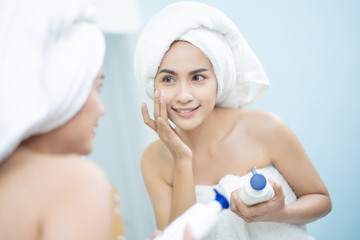 Asian women a face lotion after a shower.