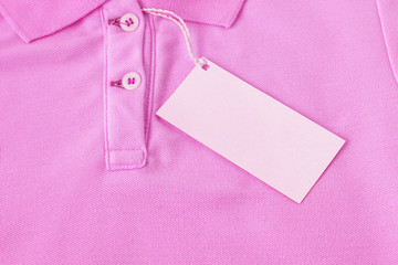 Wall Mural - Blank tag label on pink shirt background.