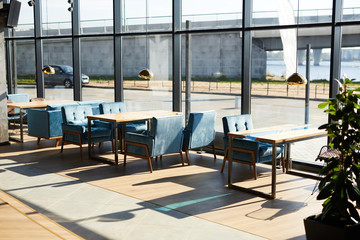 Wall Mural - Windows of modern cafe and row of tables and chairs along them inside