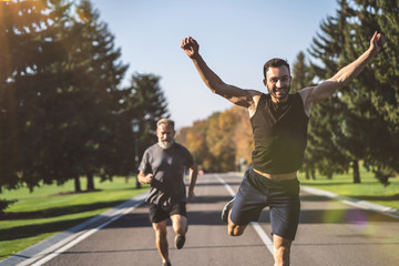 Sticker - The two men running on the road in the park on the sunny background