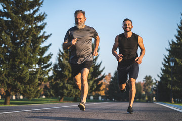 the father and a son running on the park road