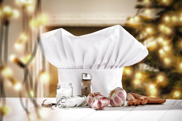 Wall Mural - White cook hat on white wooden table and christmas decoration. Free space for your products. 