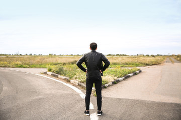 Young man standing at crossroads. Concept of choice