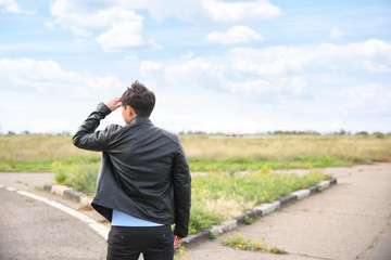 Young man standing at crossroads. Concept of choice