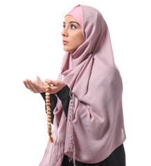 Wall Mural - Young Muslim woman praying on white background