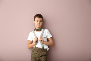 Wall Mural - Cute boy in fashionable clothes on color background