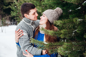 Wall Mural - Young couple hugging and kissing in the Park in winter.