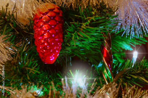Fotografering Mysterious Christmas background with vintage Christmas decorations on an artificial fir tree with a luminous garland