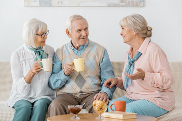 Wall Mural - senior people drinking coffee and talking in nursing home