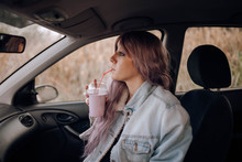 Stylish Woman Having Drink In Car