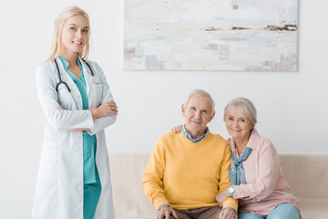 Wall Mural - female doctor standing near senior smiling patients in clinic