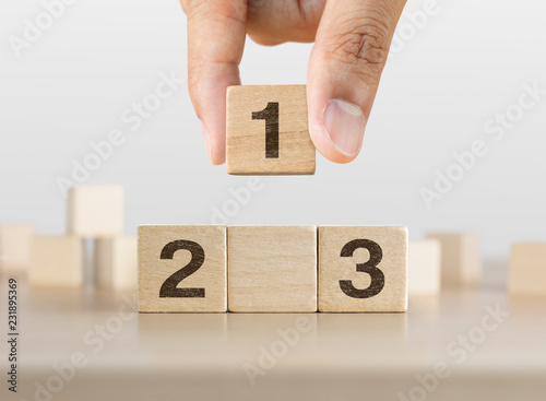 Fotografía Hand arranging wooden blocks stacking as a podium on white background