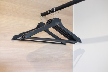 Empty black plastic hanger in wood closet