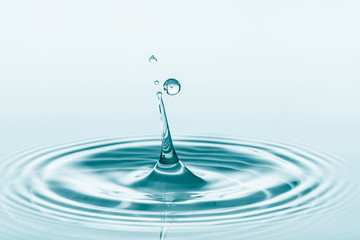 Wall Mural - water drop falling into water making a perfect droplet splash
