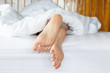 © 220 Selfmade studio - Close up two feet of woman sleep on white bed in bedroom,Feeling relax and comfortable,Healthcare Concept
