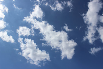 white puffy clouds deep blue sky sun formation composition moving fast