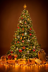 christmas tree lighting in night, xmas decorations hanging on chritmastree, star top light and prese
