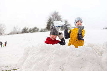 snow battle in the fortress. children throw snowballs in the park.