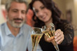 © ElitProd - Happy elegant middle-age couple celebrating something with champagne at home