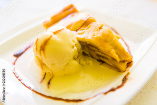 Fotografia, Obraz Piece of apple pie with ice cream next to it on plate, sweet dessert concept