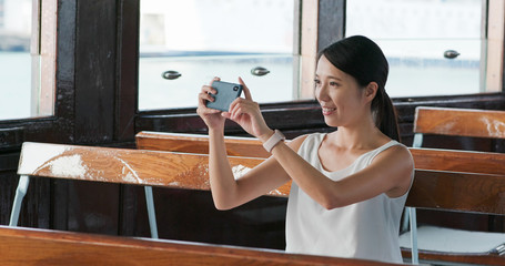 Sticker - Woman taking photo on cellphone on ferry