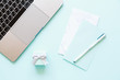 © Алина Бузунова - Flatlay of laptop, paper, pen and little gift box on a blue background